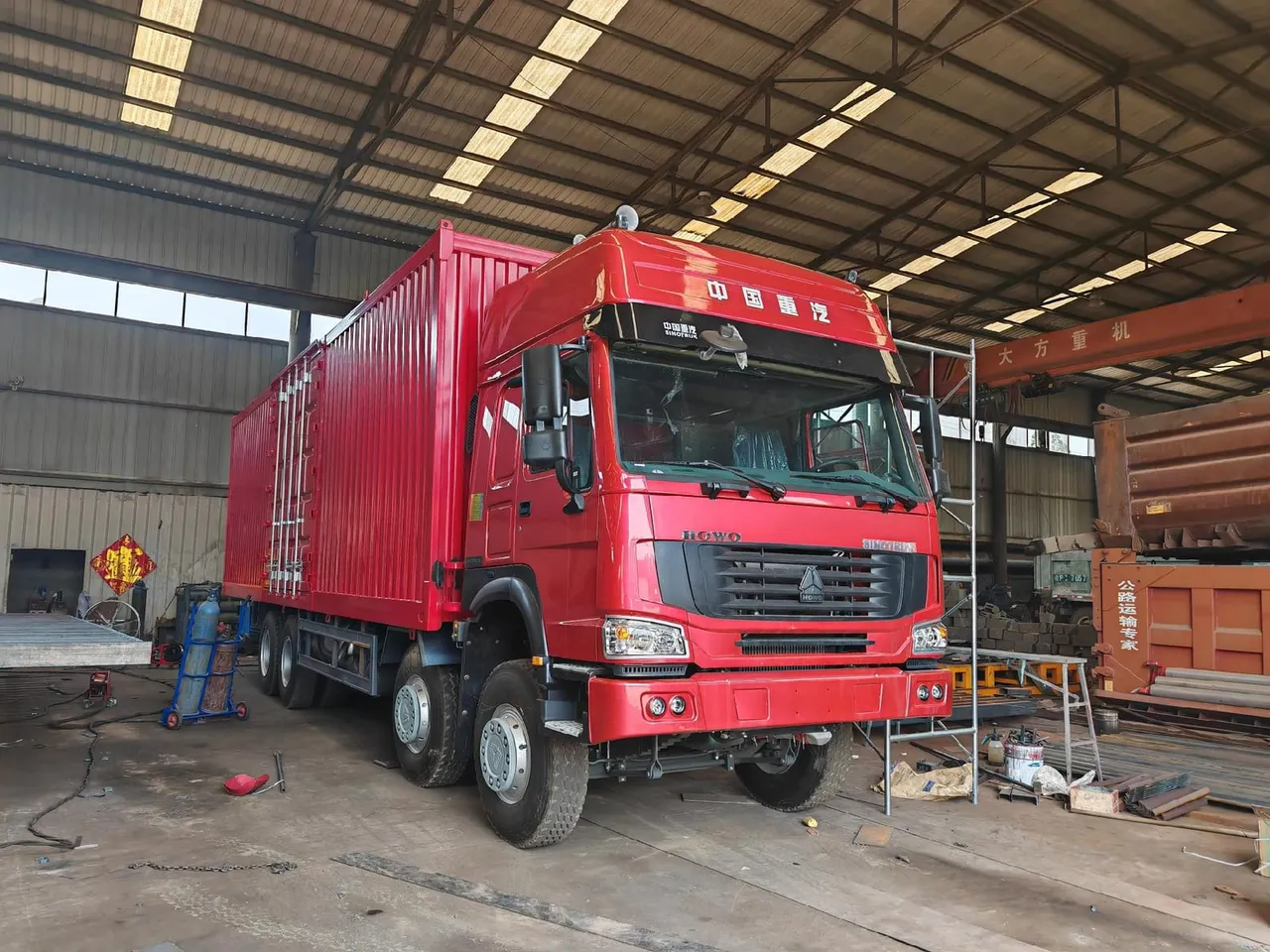 Used HOWO box truck with enclosed dry van body parked at export yard, ready for CIF shipment to Africa
