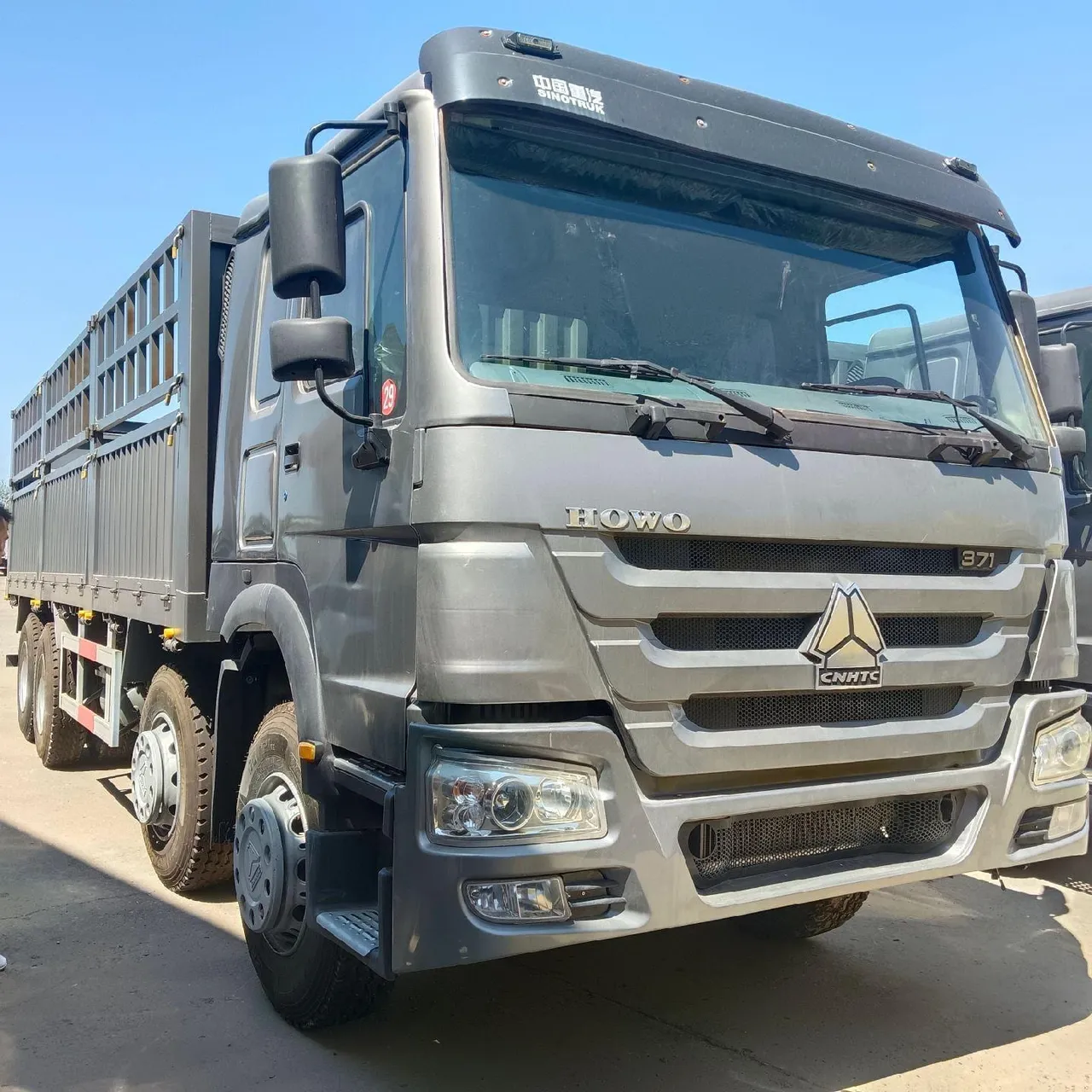 Used curtain-side cargo truck with HOWO chassis and side curtain open showing pallet load