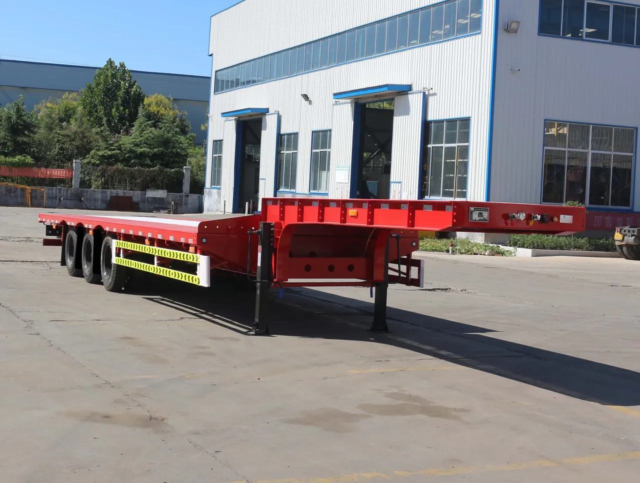 Used tri-axle flatbed semi-trailer with open steel deck ready for export