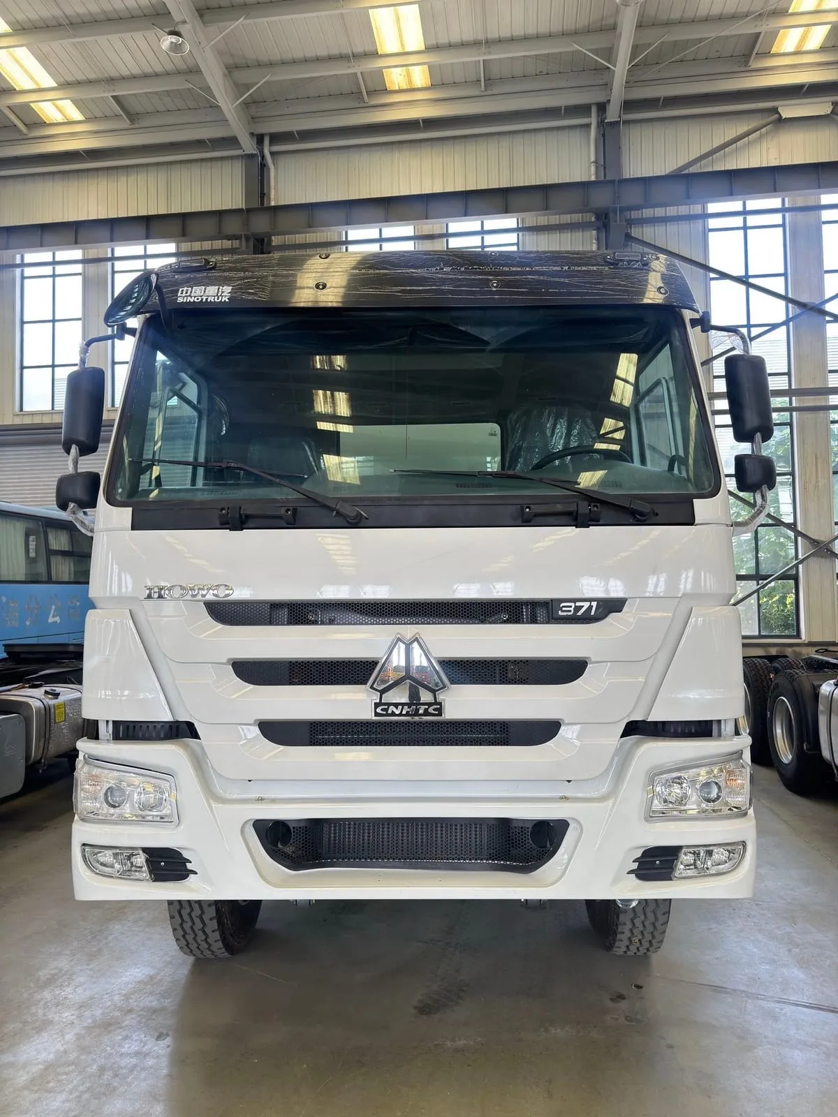 Row of Chinese vocational trucks including tow truck wrecker and vacuum tanker ready for export
