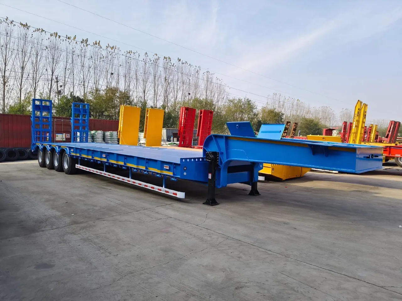 Used low bed trailer loaded with heavy construction equipment for export